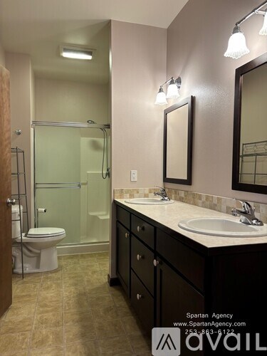 A bathroom with a toilet, sink, and mirror.