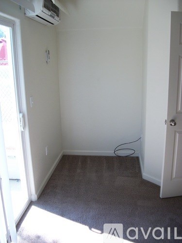 A room with a carpeted floor and a door.