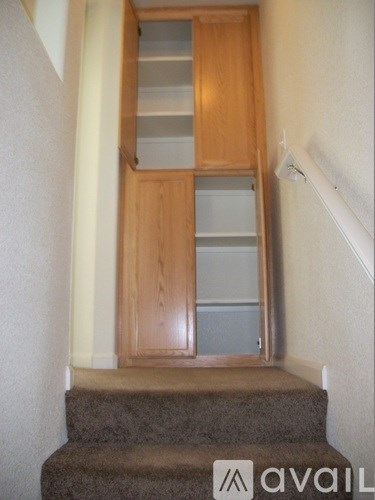 A staircase with a wooden banister and steps leading up to a wooden door with frosted glass.