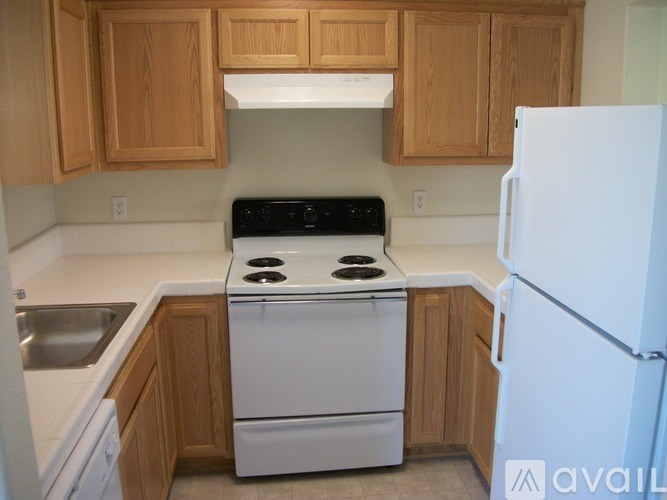 A kitchen with wooden cabinets and a white fridge.