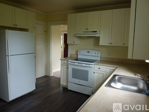 A kitchen with white appliances and cabinets.
