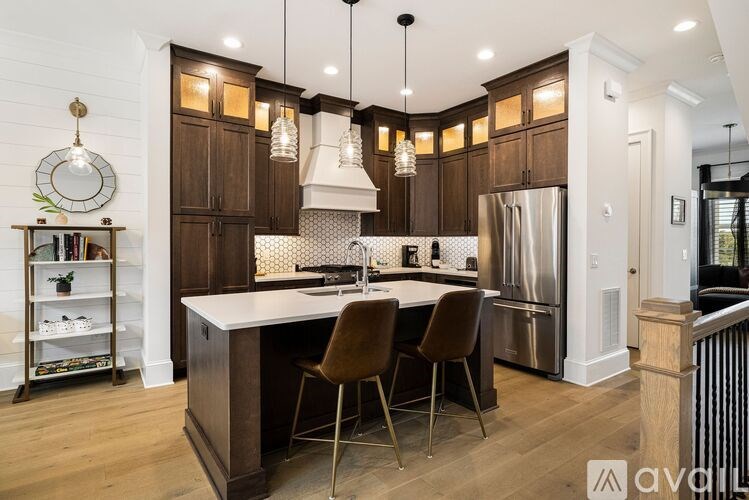 A modern kitchen with dark wood cabinets and a white island.