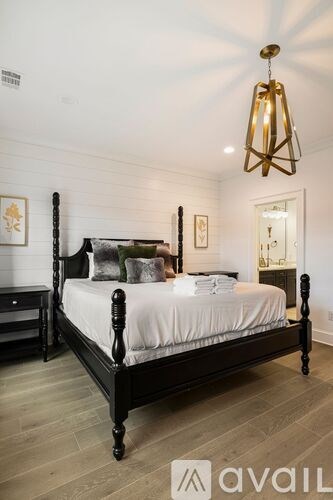A bedroom with a large bed and a chandelier.