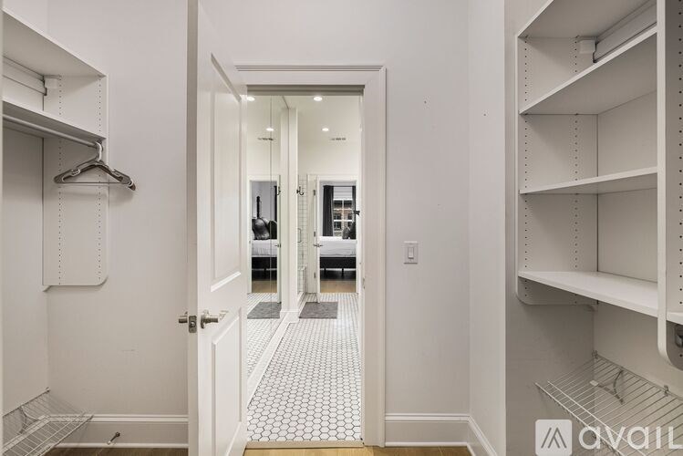 A hallway with a white door and a tiled floor.