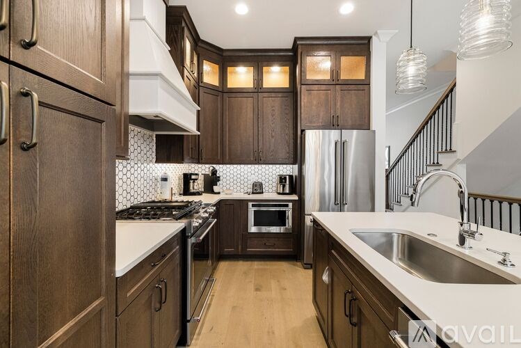 A kitchen with wooden cabinets and a stainless steel refrigerator.