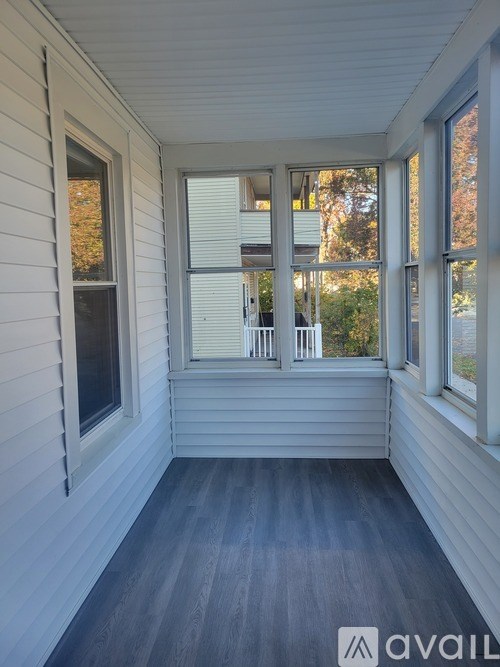 A balcony with a white railing and a window with blinds.