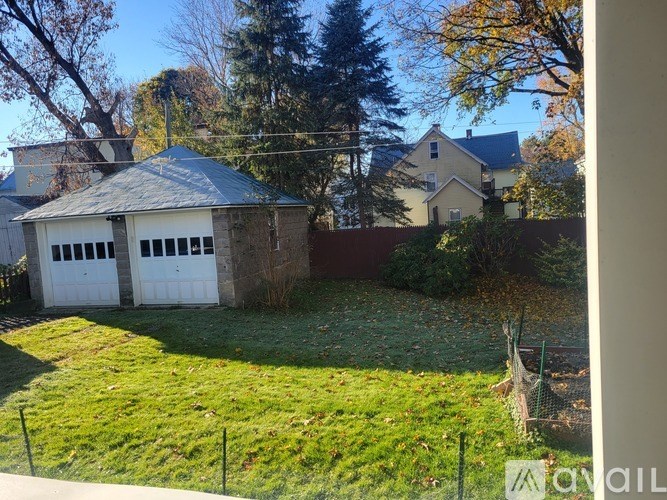 A backyard with a shed and a fence.