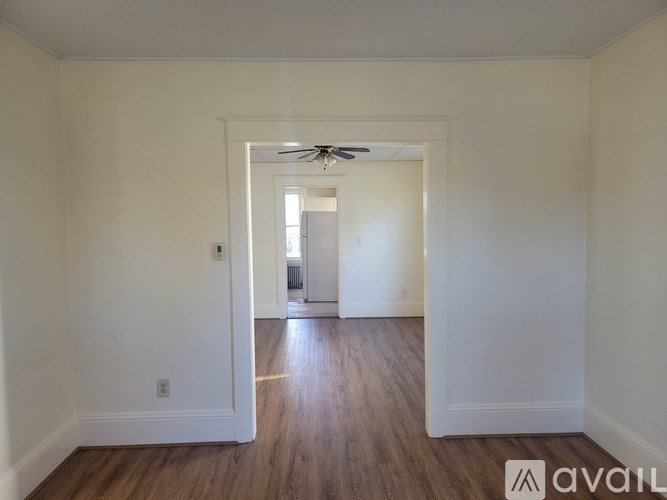 A room with a wooden floor and a ceiling fan.