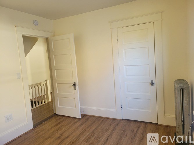 A room with two white doors and a radiator on the wall.