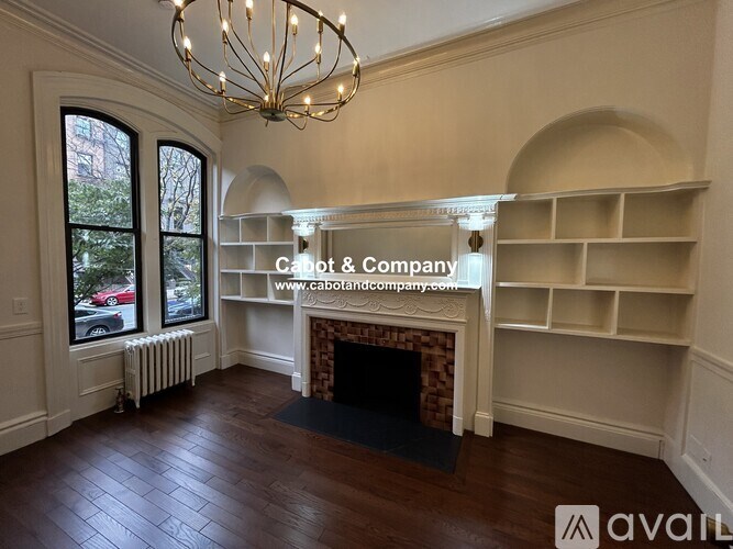 A large room with a fireplace and a chandelier.