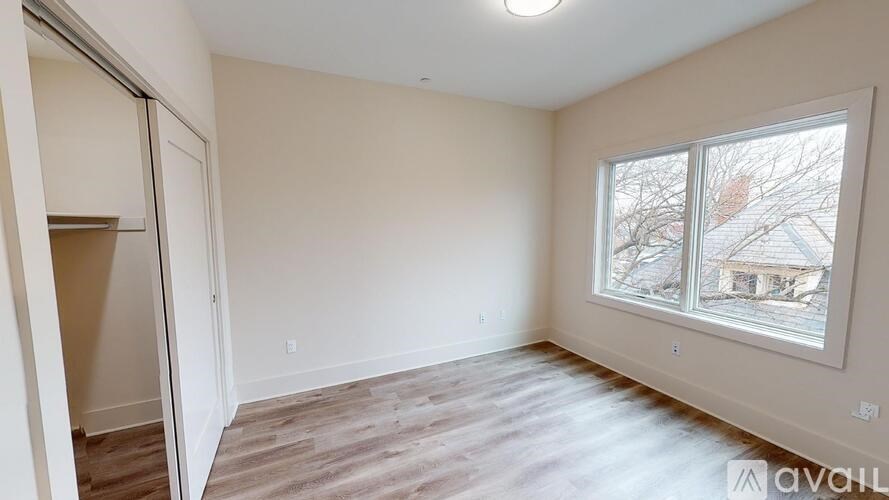 A room with a sliding door and a window showing a view of a house.