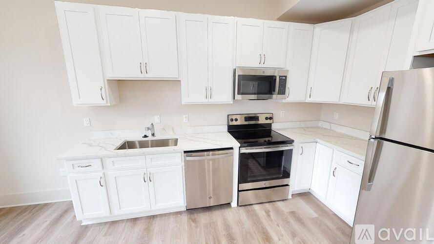 A kitchen with white cabinets and stainless steel appliances.