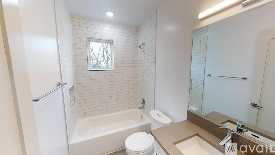 A white bathroom with a toilet, sink, and bathtub.
