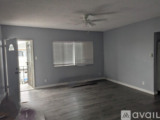 A room with a ceiling fan and a window with blinds.