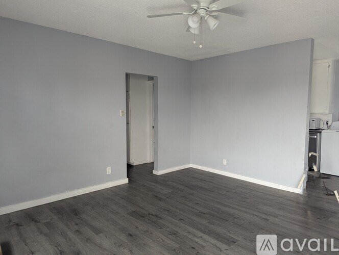 A room with a ceiling fan and a door.