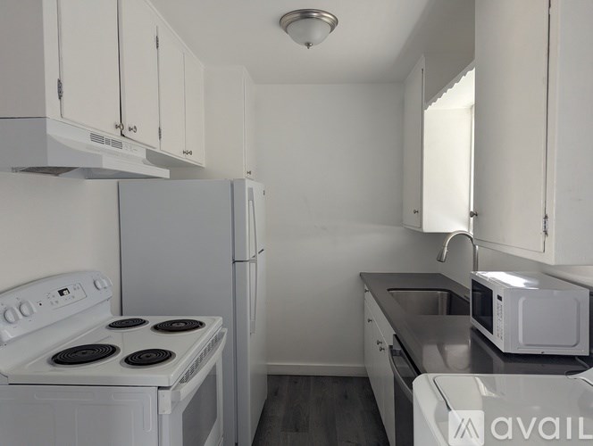 A kitchen with white appliances and cabinets.