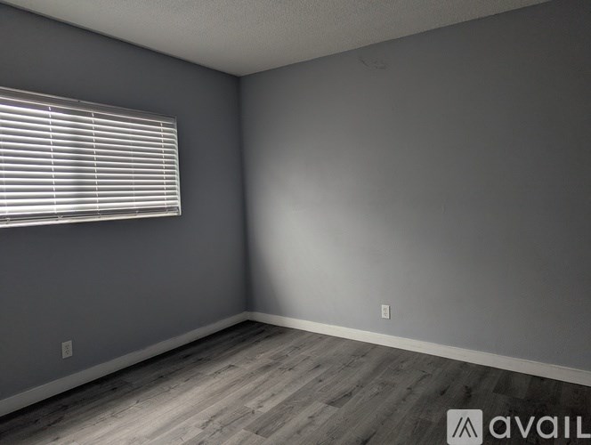 A room with a window and wooden flooring.