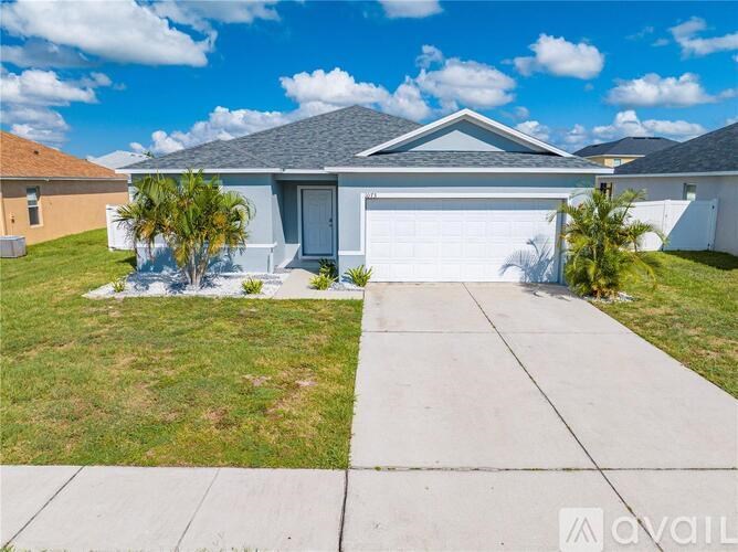 A house with a grey roof and a white garage door is for sale.