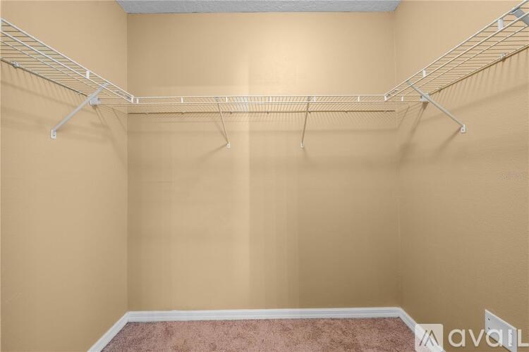 Empty room with a carpeted floor and a wall-mounted shelving unit.