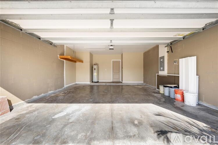 A large empty room with a concrete floor and walls, and a door in the middle.