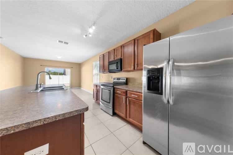 A kitchen with a granite countertop and stainless steel appliances.