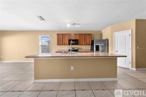 A kitchen with brown cabinets and a countertop is available for rent.