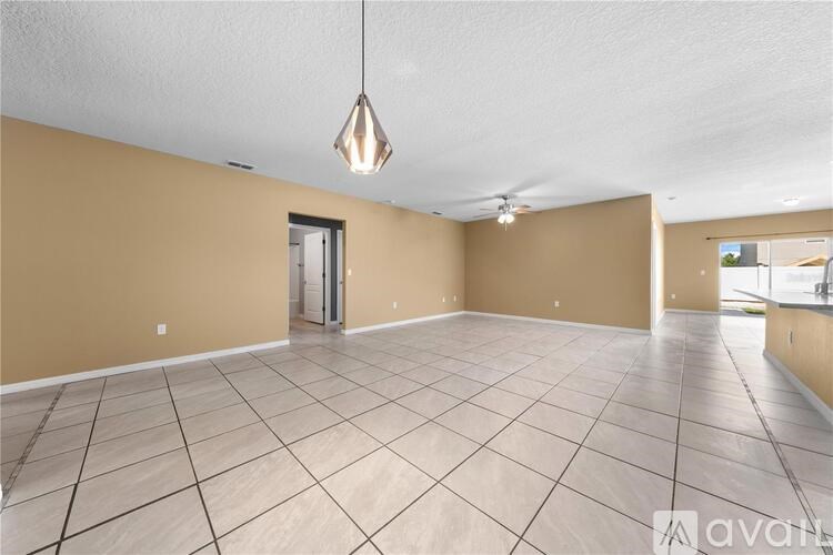 A spacious room with a tiled floor and a hanging light fixture.