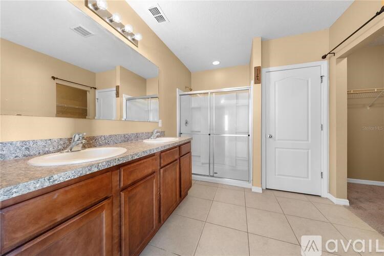 A bathroom with a double sink vanity and a walk-in shower.