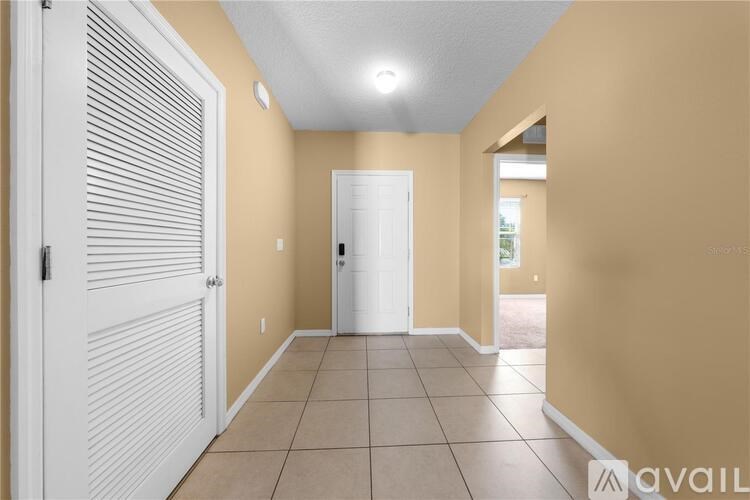 A hallway with a white door and a white shuttered window.
