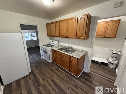 A kitchen with wooden cabinets and a white refrigerator.