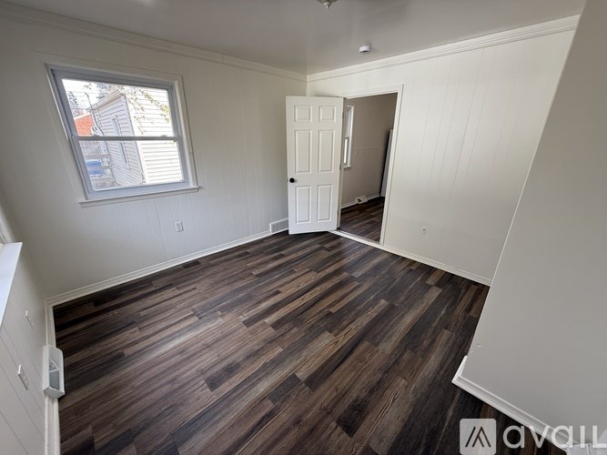 A room with wooden flooring and a white door.