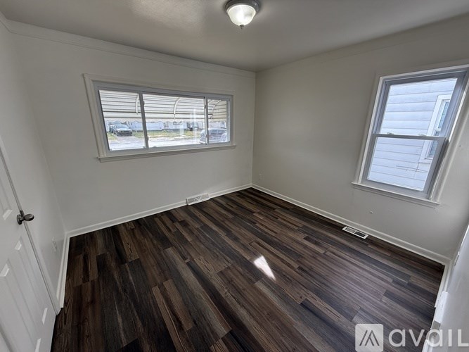 A room with a window and wooden flooring is available for rent.