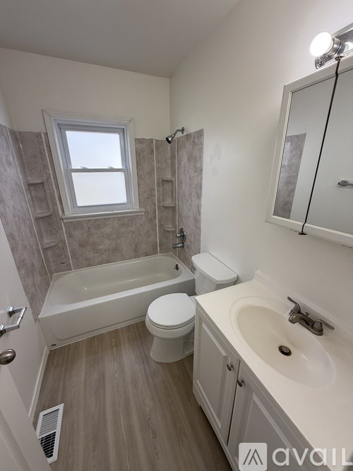 A bathroom with a tub, toilet, and sink.