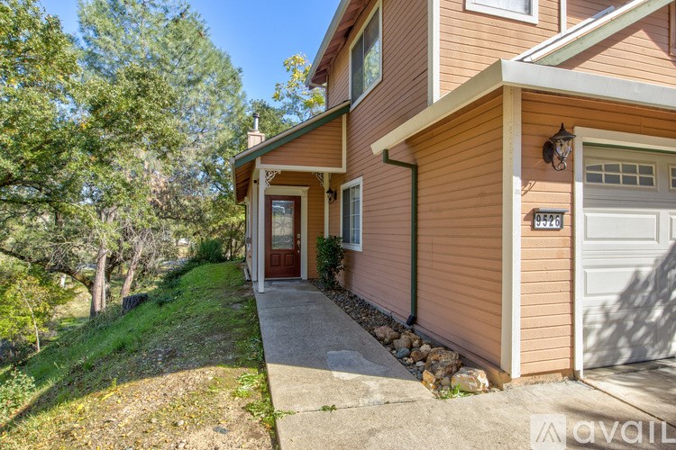 A house with a brown siding and a white door is for sale.