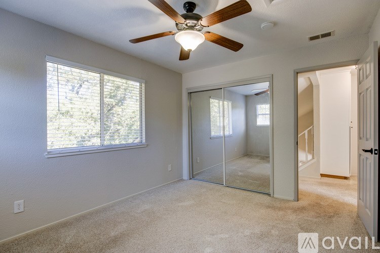 A room with a ceiling fan and a window.