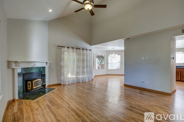 A spacious living room with a fireplace and hardwood floors.