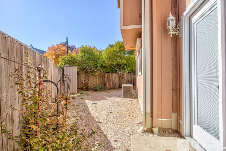A backyard with a gravel path and a wooden fence.