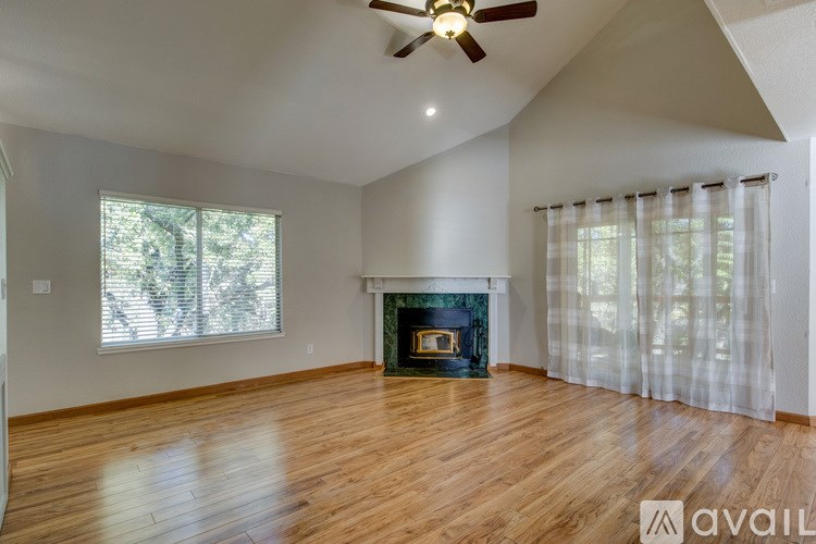 A living room with a fireplace and a ceiling fan.