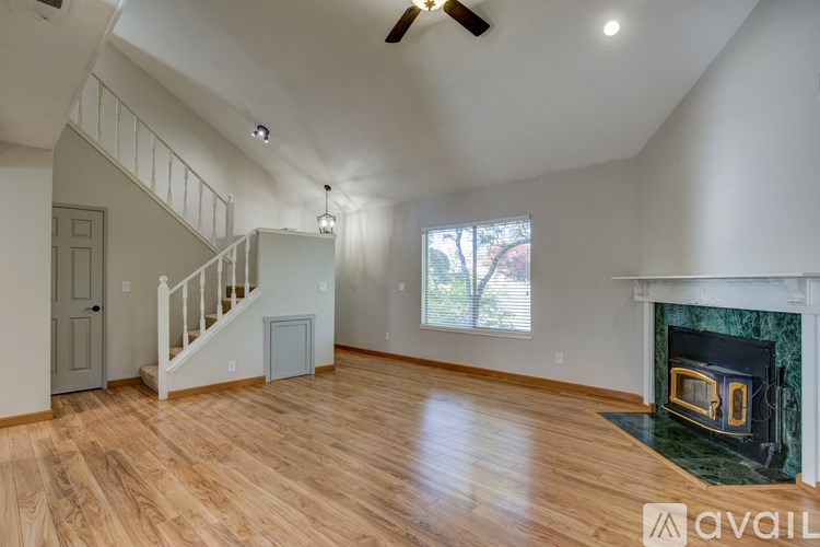 A spacious living room with wood flooring and a fireplace.
