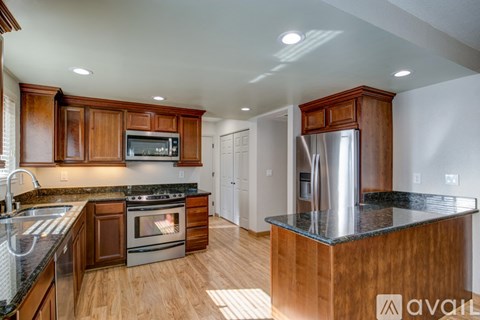 A kitchen with wooden cabinets and a stainless steel refrigerator.