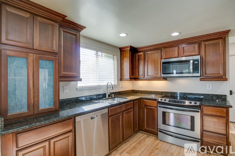 A kitchen with wooden cabinets and a black countertop.