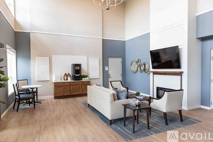 A living room with a white couch, a wooden cabinet, a TV, and a chandelier.