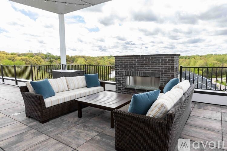 A patio with a couch, table, and a fireplace.