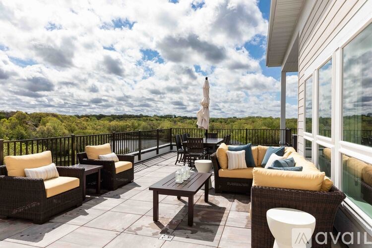 A patio with wicker furniture and a view of the sky.