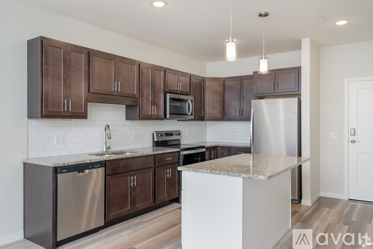 A kitchen with brown cabinets and stainless steel appliances.