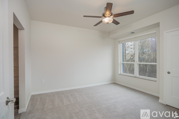 A room with a ceiling fan and a window.