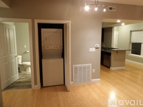 A room with a refrigerator and a small kitchenette.