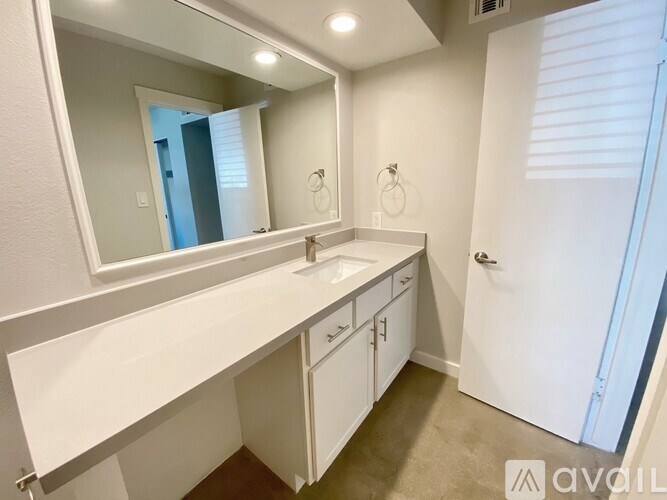 A bathroom with a sink, mirror, and towel rack.