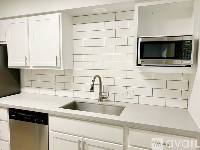 A kitchen with a black dishwasher and a black microwave.