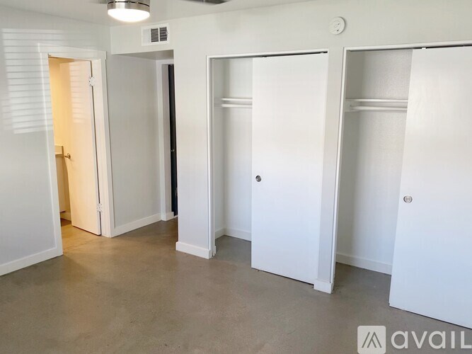 Three white closet doors in a room.